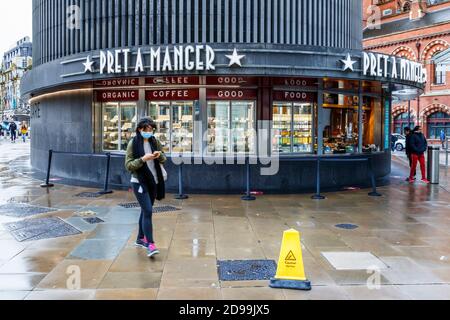 Une femme passe devant le kiosque PRET a Manger sur la piste de la gare de King's Cross, Londres, Royaume-Uni Banque D'Images