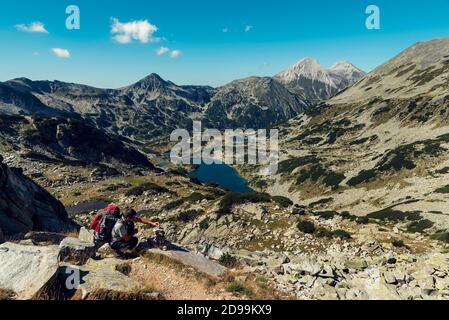 Jeune homme faisant pyramide de pierres dans la montagne de Pirin Jour d'été ensoleillé foyer sélectif Banque D'Images
