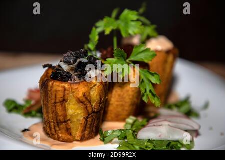 Bananes farcies de viande de jambon et sauces avec légumes autour Banque D'Images