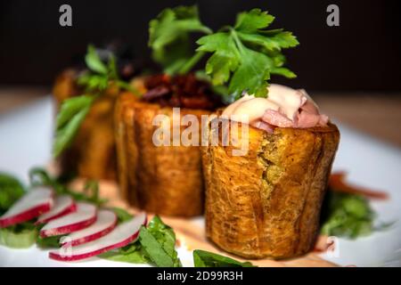 Bananes farcies de viande de jambon et sauces avec légumes autour Banque D'Images