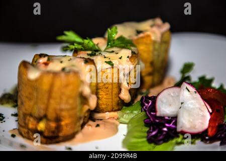 Bananes farcies de viande de jambon et sauces avec légumes autour Banque D'Images