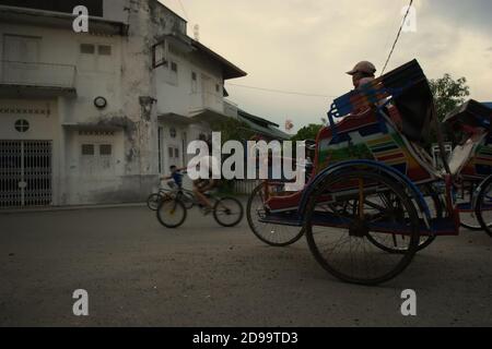 Un pilote de pousse-pousse à vélo qui attend des passagers à Sibolga, dans le nord de Sumatra, en Indonésie. Banque D'Images