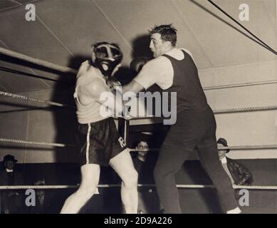 1933 , Etats-Unis : le boxeur italien PRIMO CARNERA ( 1906 - 1967 ), champion du monde de boxe Heavyweight . À l'époque qui va combattre ERNIE SCHAAF de Boston à Madison Square Garden , New York le 10 février 1933 . Carnera est entraînement pour le combat à Pompton Lakes , New Jersey . Ici, il est vu atterrir avec une gauche pendant une séance de sparring avec PHIL LIGHTFOOD - SPORT - BOX - sportivo - PESI MASSIMI - match - ring - PUGILATO - PUGILE - BOXEUR -- Archivio GBB Banque D'Images