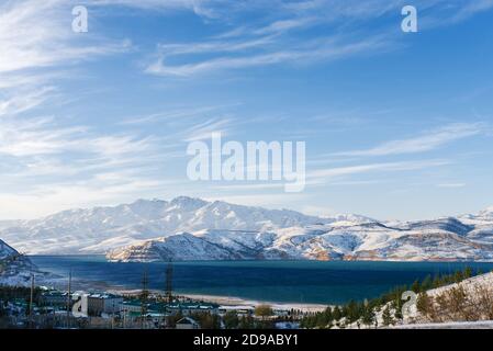 Lac de montagne Charvak en Ouzbékistan par une journée enneigée, entouré par les montagnes Tien Shan. Pyramides de Chimgan Banque D'Images