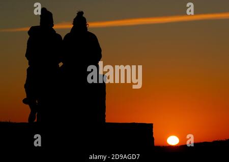 Newtown Linford, Leicestershire, Royaume-Uni. 4 novembre 2020. Météo au Royaume-Uni. Les femmes regardent le lever du soleil depuis Old John dans Bradgate Park. Credit Darren Staples/Alay Live News. Banque D'Images