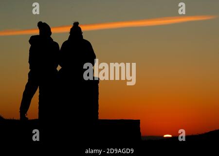 Newtown Linford, Leicestershire, Royaume-Uni. 4 novembre 2020. Météo au Royaume-Uni. Les femmes regardent le lever du soleil depuis Old John dans Bradgate Park. Credit Darren Staples/Alay Live News. Banque D'Images