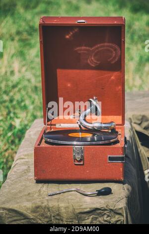 Un ancien gramophone portable joue un disque en vinyle Banque D'Images