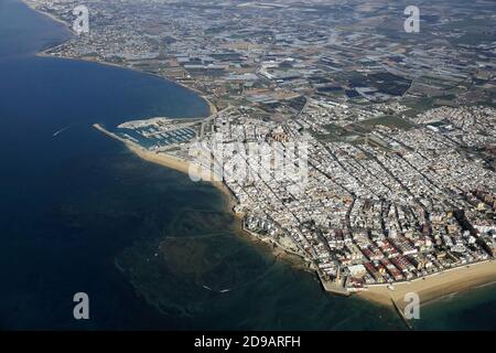 Espagne, Andalousie: Vue aérienne au printemps de la ville blanche de Chipiona sur la Costa de la Luz, et de la plaine fertile et des serres environnantes. Banque D'Images