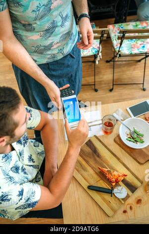 Client payant la facture du restaurant avec une carte mobile virtuelle Banque D'Images