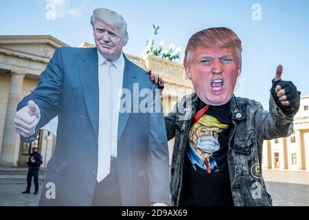 Berlin, Allemagne. 04e novembre 2020. Un partisan du président américain Trump se présente devant la porte de Brandebourg avec une exposition de carton et un masque de Trump. Plus de 200 millions d'Américains ont été appelés à élire un nouveau président et les membres de la Chambre des représentants. Credit: Fabian Sommer/dpa/Alay Live News Banque D'Images