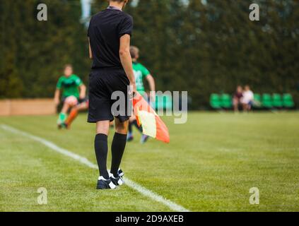 Jeune arbitre de football sur le drapeau de garde de Sideline. Les joueurs de football de niveau junior participent à un match de tournoi Banque D'Images