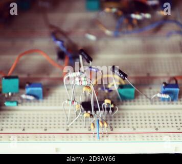 Carte d'expérimentation pour tester des prototypes de circuits électroniques et de composants sans soudure, ici avec des circuits intégrés, des condensateurs et des résistances clippés Banque D'Images