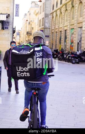 Bordeaux , Aquitaine / France - 11 01 2020 : Ubereats liveur à vélo livrez restaurant à emporter avec sac de marque Banque D'Images