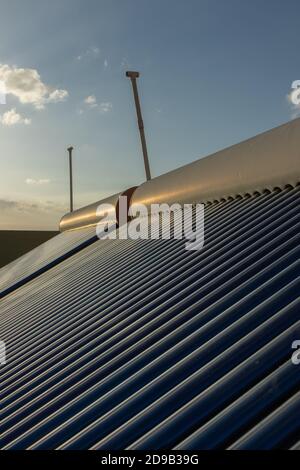 panneaux solaires et tubes installés pour le chauffage de l'eau sur le toit hauts de maisons et de bâtiments pour économiser l'énergie Banque D'Images