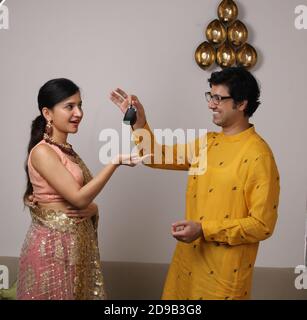 Mari indien surprenant femme avec une nouvelle voiture clés comme cadeau à Diwali / anniversaire / anniversaire. Banque D'Images