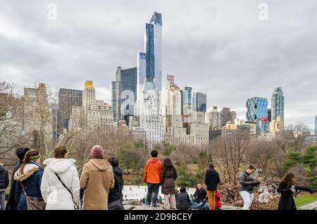 Les personnes de Central Park admirent la vue des gratte-ciels et des tours le jour de Noël. Citoyens et visiteurs célébrant des vacances à Manhattan Banque D'Images