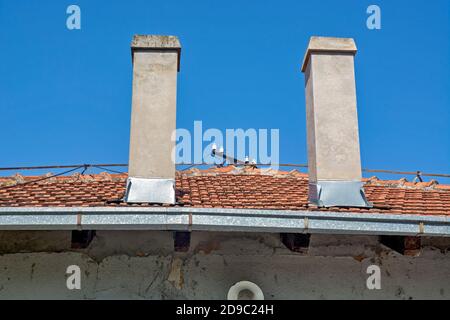 L'avant du bâtiment et deux cheminées blanches sur le toit. Banque D'Images