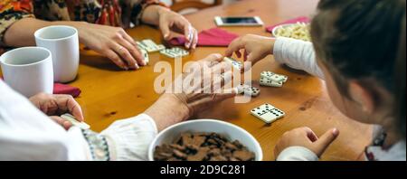 Trois générations de femmes qui jouent à domino ne sont pas reconnaissables Banque D'Images