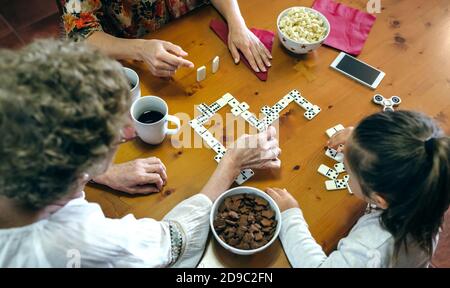Vue de dessus de trois générations de femmes jouant à domino Banque D'Images