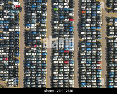 Photo aérienne de voitures garées dans une rangée structurée de stationnement voitures de location nouvelle industrie de production Banque D'Images