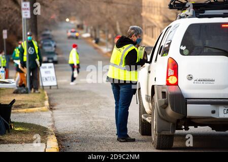 Helena, Montana / le 3 novembre 2020 : femme fonctionnaire d'élection aidant l'électeur au bureau de vote, le vote de stationnement en véhicule, le vote du jour de l'élection présidentielle, Banque D'Images