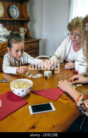 Trois générations de femmes jouant avec des dominos Banque D'Images