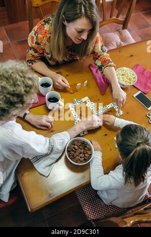 Vue de dessus de trois générations de femmes jouant à domino Banque D'Images