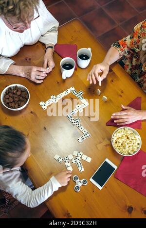 Vue de dessus de trois générations de femmes jouant à domino Banque D'Images