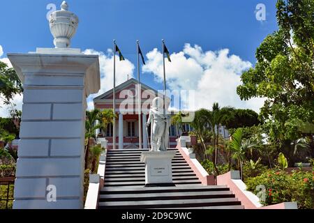 Le choix et blanc de la maison néoclassique du gouvernement à Nassau, Bahamas. Une statue de Christophe Colomb se trouve sur l'escalier devant trois drapeaux. Banque D'Images