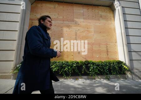 Une personne passant par un magasin Ralph Lauren embarqué le long de Madison Avenue à New York. Banque D'Images