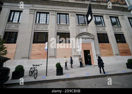 Les gens attendent devant un Apple Store à bord le long de Madison Avenue à New York. Banque D'Images
