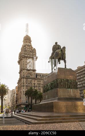 Montevideo, Uruguay- 18 décembre 2008 : statue de José Gervasio Artigas sur son cheval au sommet d'un piédestal en pierre, regardant Palacio Salvo sous la sk argentée Banque D'Images