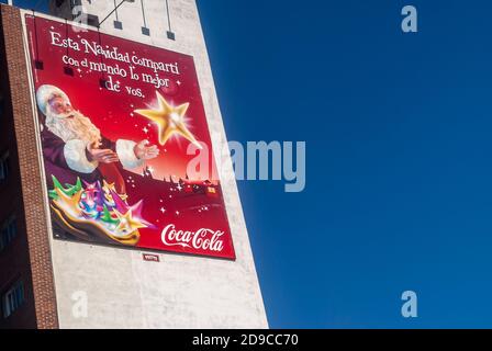 Montevideo, Uruguay- 18 décembre 2008: Gros plan de la bannière de noël rouge Coca-Cola contre le mur blanc et flanqué d'un ciel bleu profond. Le Père Noël et le ged Banque D'Images