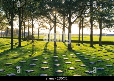 Croisements de pierres et sépultures de la première Guerre mondiale au cimetière de guerre allemand de Langemark au coucher du soleil à Langemark-Poelkapelle, Belgique Banque D'Images