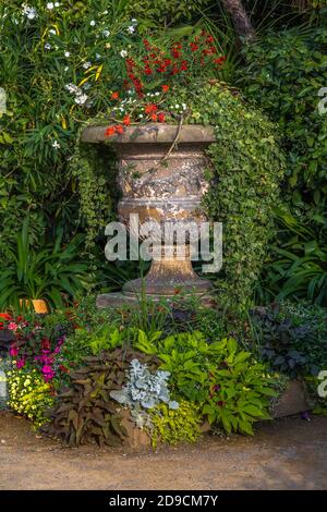 Vase en pierre antique avec fleurs dans le parc Banque D'Images