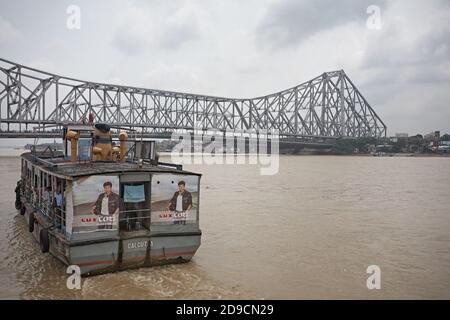 Kolkata, Inde, juillet 2009. Ferry pour passagers sur le Gange River avec Howrah Bridge en arrière-plan. Banque D'Images