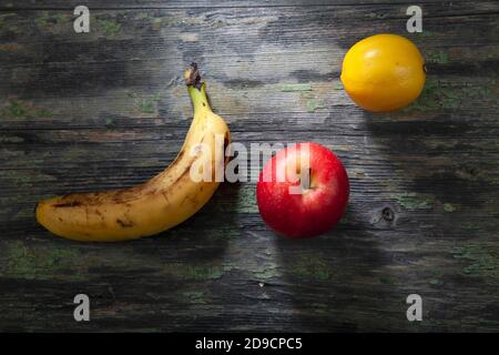 La vie de Banana, citron et pomme sur fond de bois décalé Banque D'Images