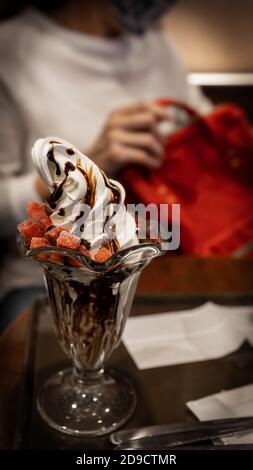 Un délicieux dessert de sundae au chocolat avec des tranches de fraises congelées. Banque D'Images