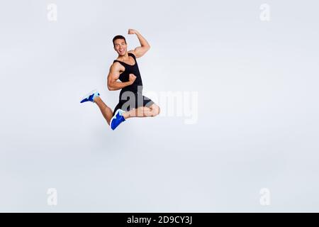 Vue sur toute la longueur du corps de son beau attrayant musclé sportive gai gai gai gai gars jumping célébrant se réjouir avoir tasse amusante isolée Banque D'Images