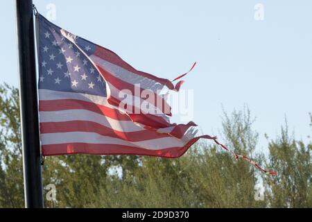 Mesa, États-Unis. 04e novembre 2020. Un drapeau américain vole en lambeaux dans la maison d'un supporter de Donald Trump à Mesa, Arizona, États-Unis, le 4 novembre 2020. L'État typiquement républicain a voté pour l'ancien vice-président Joe Biden et a également élu un sénateur démocrate, Mark Kelly, au Sénat américain. L'État s'est retourné "bleu" en opposition au président en exercice, ce qui n'est pas arrivé depuis 1948. (Photo par Alexandra Buxbaum/Sipa USA) crédit: SIPA USA/Alay Live News Banque D'Images