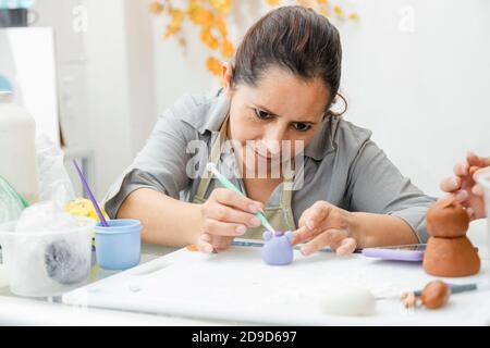 Femme hispanique travaillant dans sa pâtisserie - Latina femme travailler avec fondant pour décorer un gâteau - pâtisserie entrepreneur chef - femme faisant l'artisanat avec Banque D'Images