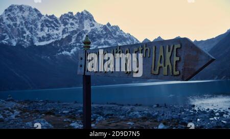 Panneau dans le village de Sherpa Gokyo, parc national de Sagarmatha, Népal montrant la direction vers les quatrième et cinquième lacs dans la lumière du soir. Banque D'Images