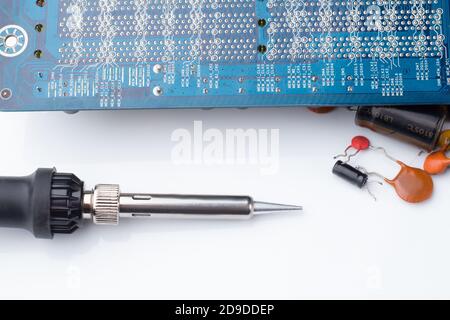 Fer à souder , carte d'ordinateur et condensateurs. Le concept de réparation et de service. La vue de dessus Banque D'Images