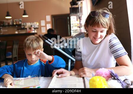 Mère et fils avec livre de menu dans un restaurant Banque D'Images