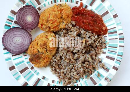 Sarrasin bouilli avec des côtelettes et des oignons sur l'assiette Banque D'Images