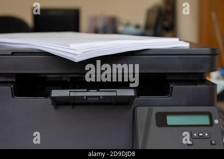 Espace de travail de bureau avec imprimante et feuilles de papier vierges sur le couvercle de l'imprimante, mise au point sélective, espace de copie Banque D'Images