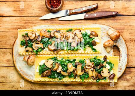 Lasagnes aux champignons, au fromage et aux épinards sur une table en bois. Cuisine italienne traditionnelle. Banque D'Images