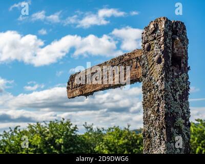 Un vieux panneau en bois recouvert de lichens pointant vers le Direction Lennoxtown Banque D'Images