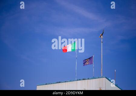 Drapeau de l'Italie et drapeau bleu avec ancre dorée sur un bâtiment avec ciel bleu en arrière-plan Banque D'Images