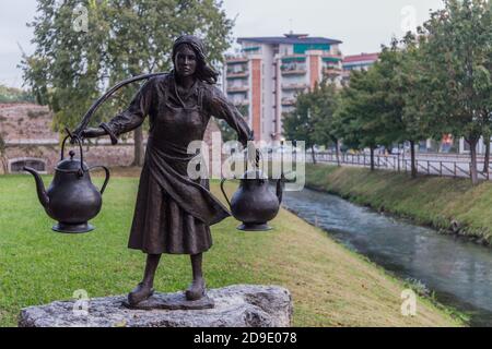 Statue d'une femme portant deux cruches entre les mains avec la rivière Botteniga en arrière-plan. Trévise Italie Banque D'Images